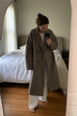 A creator showing a jacket to camera in daylight